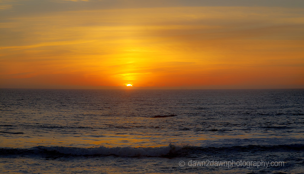 The sun sets over the Pacific Ocean near San Simeon, California