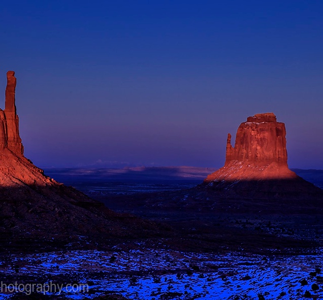 A full moon rises above a snow-covered Monument Valley, Arizona
