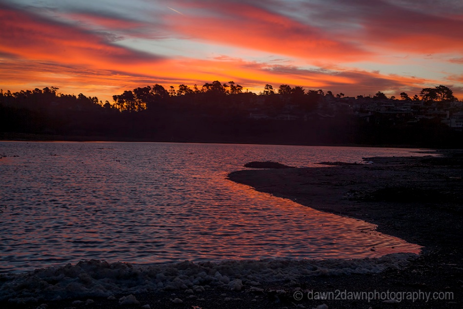 The sun rises over a lagoon at the Pacific Ocean at Cambria, California