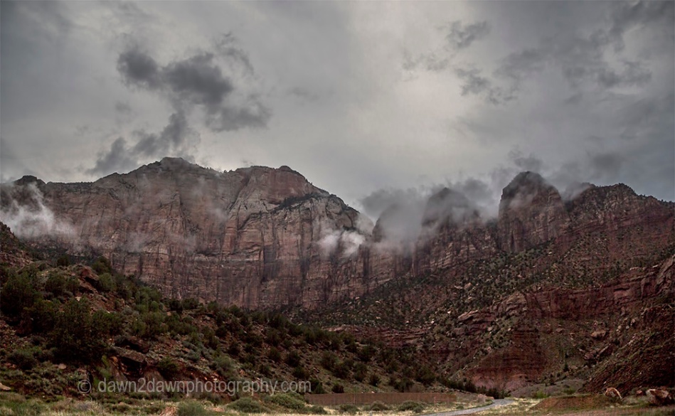 A passing thunderstorm deposits clouds around West Temple at Zion National Park, Utah