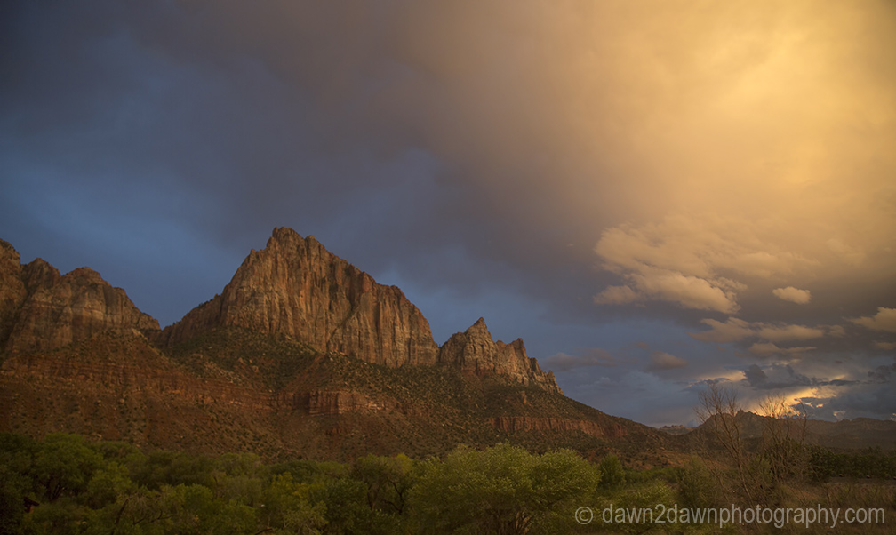 The light from the setting sun shines on the The Watchman at Zion National Park, Utah