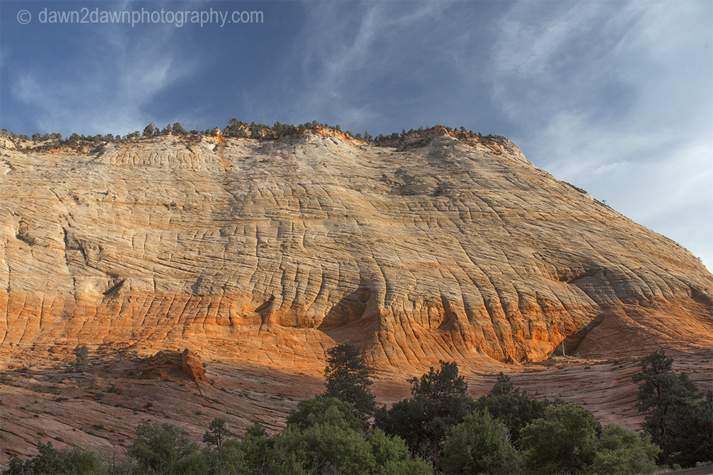 The light from the setting sun shines upon "Crazy Quilty Mesa" at Zion National Park, Utah