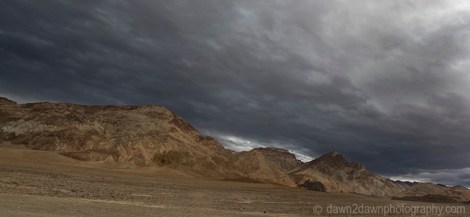 Passing storm clouds filter sunlight on the landscape at Badwater Basin at Death Valley National Park, California